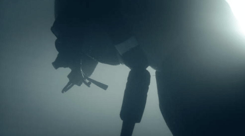 Screenshot 2026-03-15 at 234858 - N9BO℠ | Global Underwater Services Ltd A silhouette of a scuba diver underwater, with breathing equipment visible and a soft, diffused light illuminating the scene.