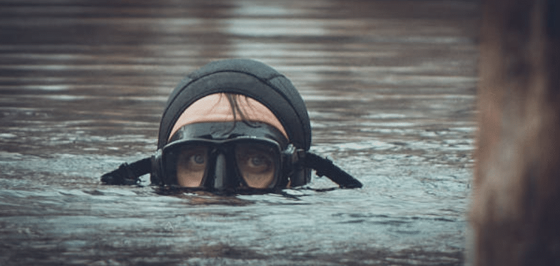 Screenshot 2026-03-15 at 235502 - N9BO℠ | Global Underwater Services Ltd A person wearing a black diving mask and wetsuit is partially submerged in water, with only their eyes and forehead visible above the surface.