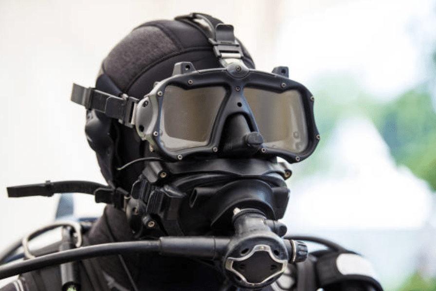 Screenshot 2026-03-16 at 222453 - N9BO℠ | Global Underwater Services Ltd A person wearing a full-face scuba diving mask, diving suit, and breathing apparatus, prepared for underwater exploration or technical diving.