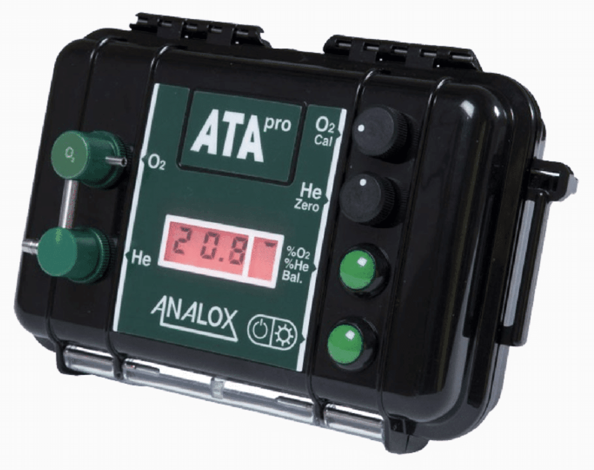 A black and green handheld ATA Pro ANALOX gas analyser with digital display screen showing 20.8, control knobs, buttons, and labelled indicators for O2 and He gases.